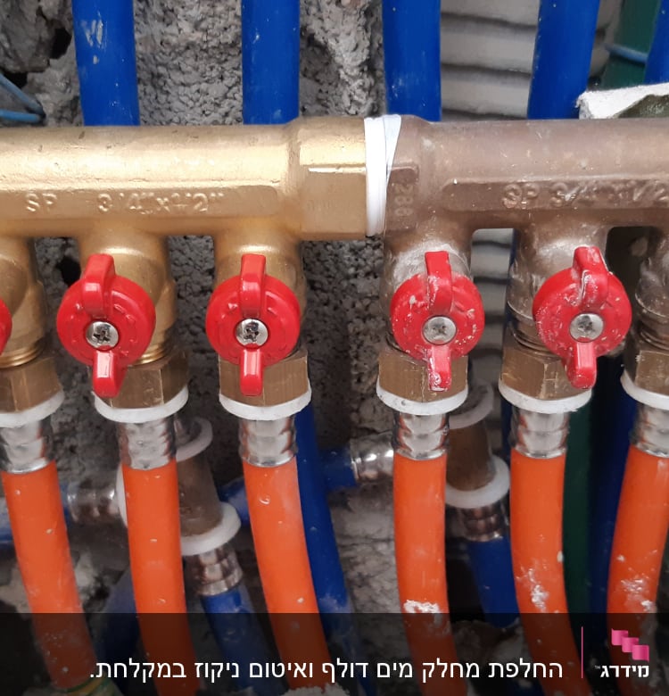 ברזים אדומים על צינורות פלסטיק כחולים וכתומים